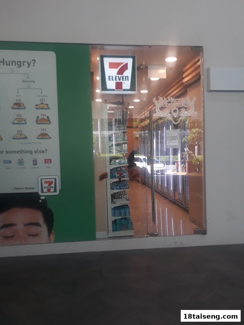 The storefront of a 7-Eleven convenience store, featuring its logo and a promotional poster.