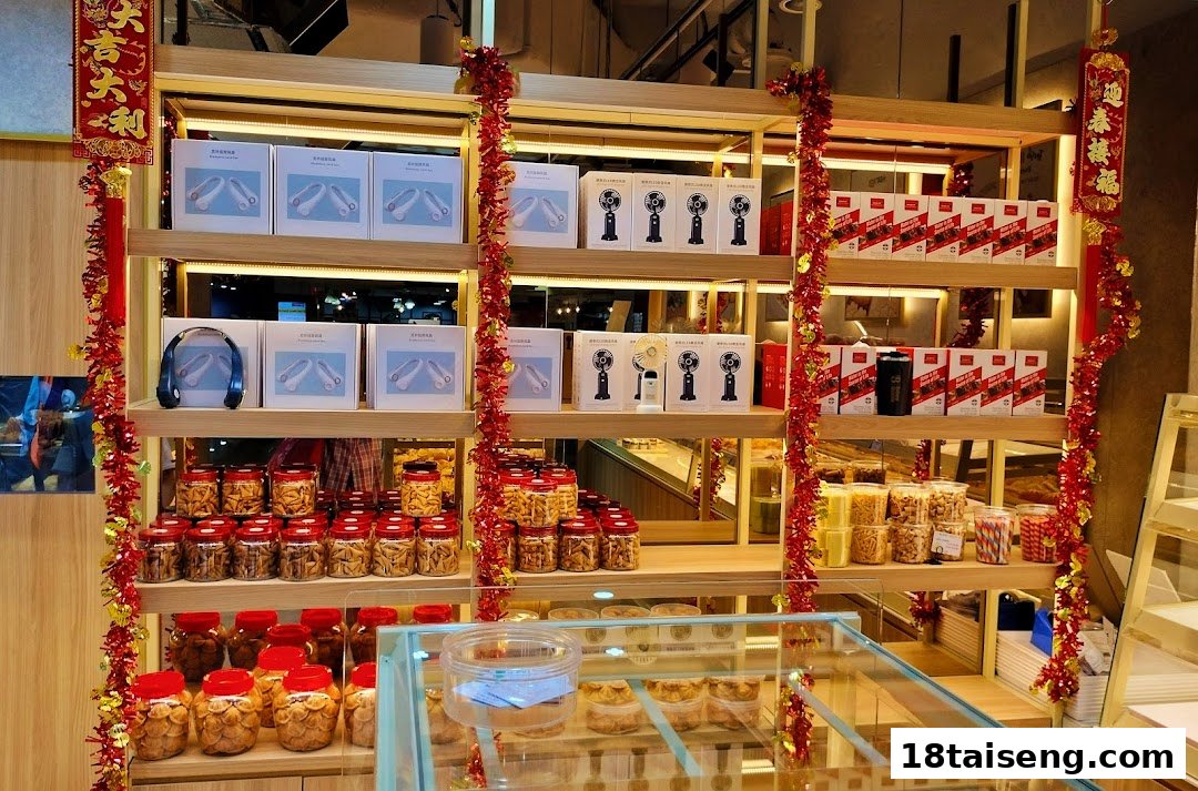 A retail display inside 'Eat Rich' featuring shelves of packaged snacks, electronic gadgets, and festive red and gold decorations.