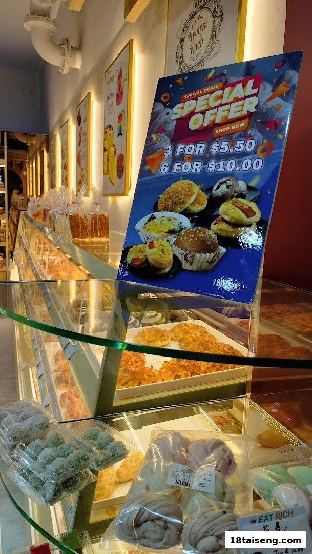 An interior shot of Eat Rich bakery showcasing display cases filled with baked goods and a prominent special offer sign.