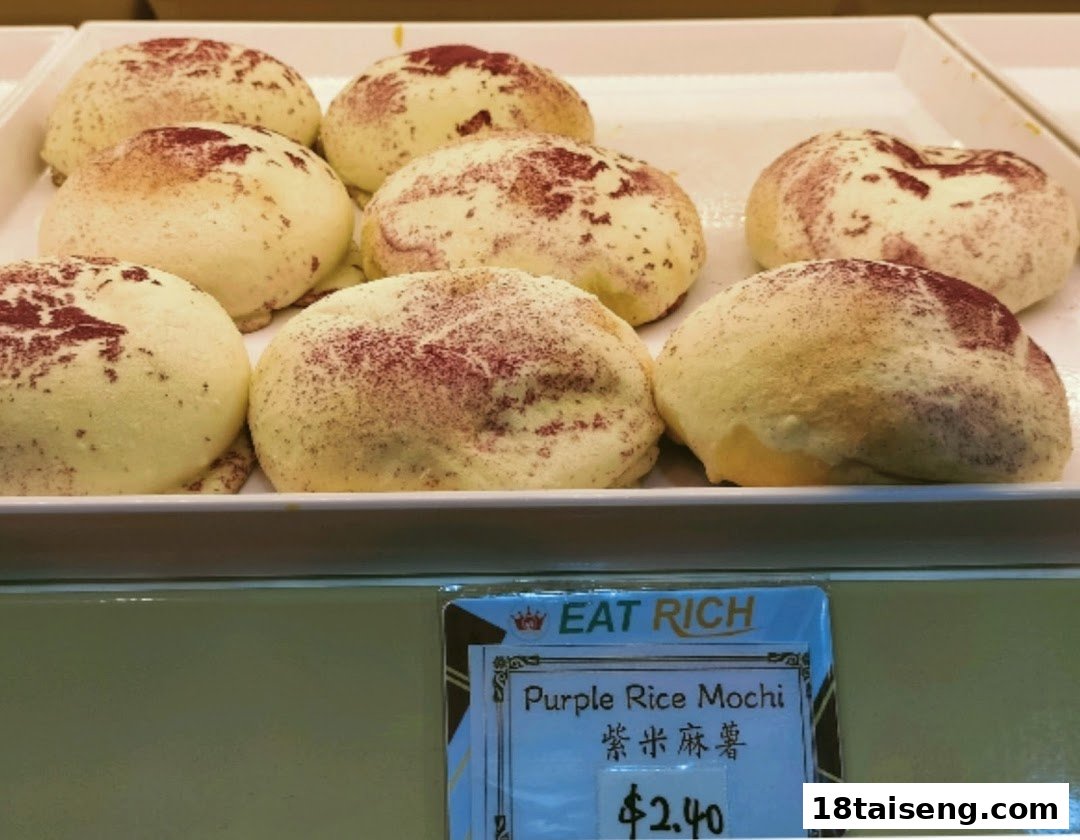 A tray of fluffy, round purple rice mochi dusted with purple powder, with a price tag visible.