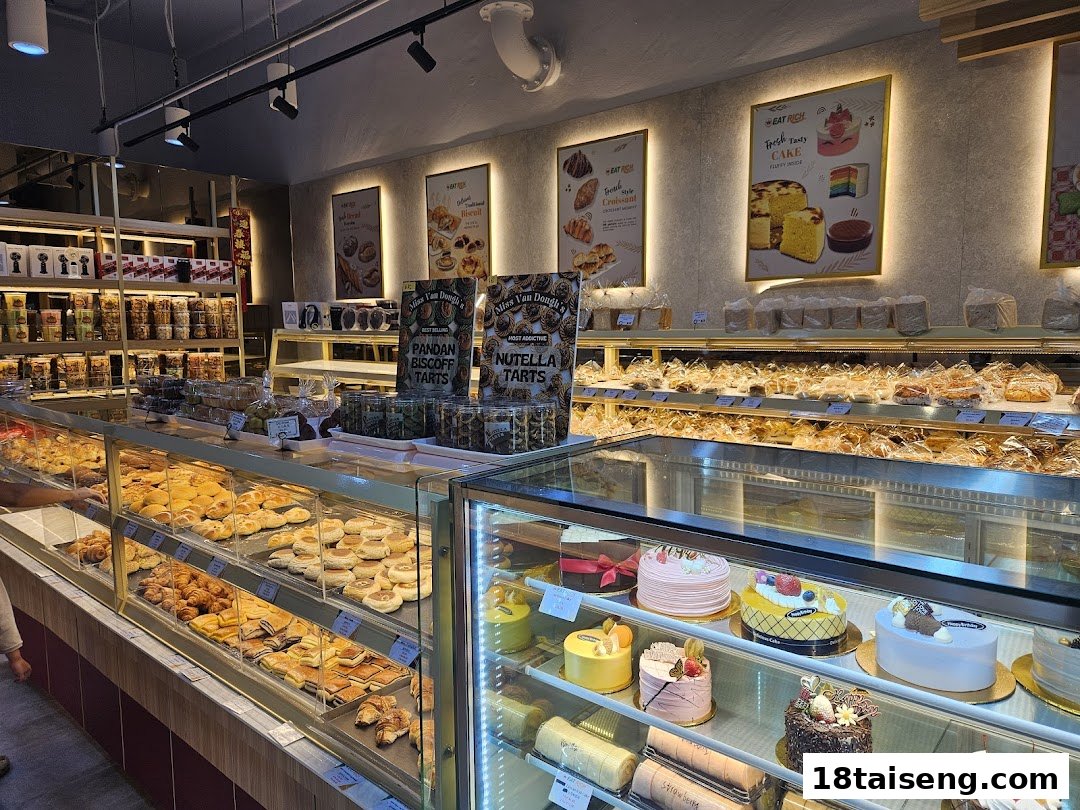 A vibrant interior shot of Eat Rich bakery, showcasing a wide array of fresh pastries, cakes, and packaged goods.