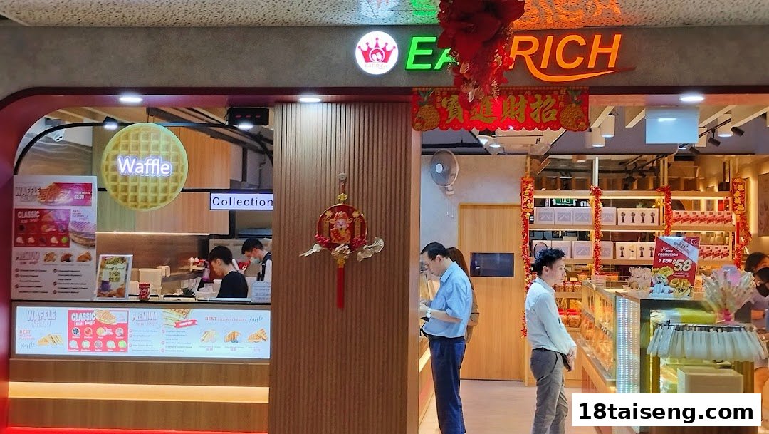 Interior view of Eat Rich bakery, prominently displaying waffle menu options and other baked goods.