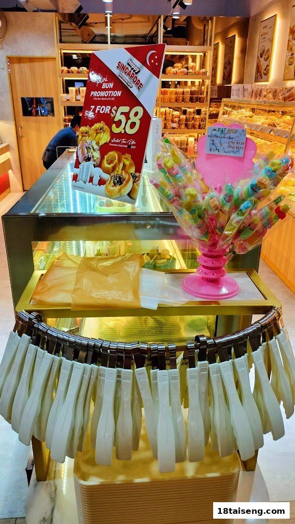 An interior view of Eat Rich bakery, featuring a bun promotion display and colorful marshmallow skewers.