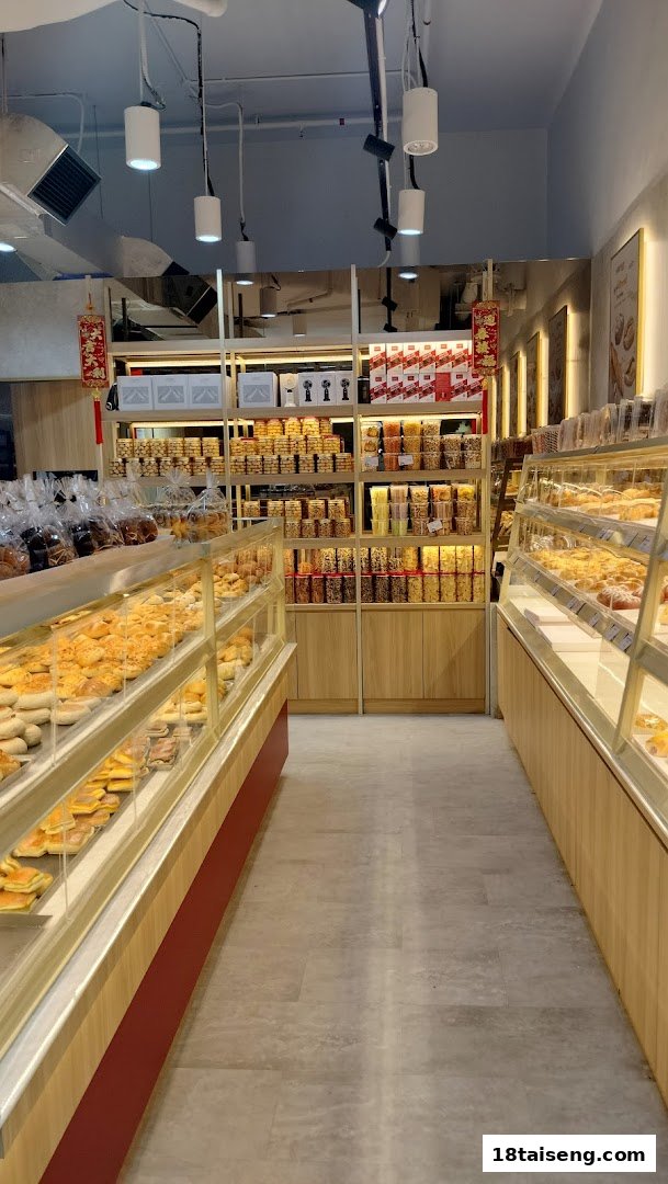 An interior view of Eat Rich bakery, showcasing display cases filled with pastries and shelves stocked with packaged snacks.