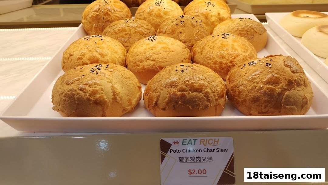 A display tray filled with golden-brown Polo Chicken Char Siew buns, with a price tag visible.