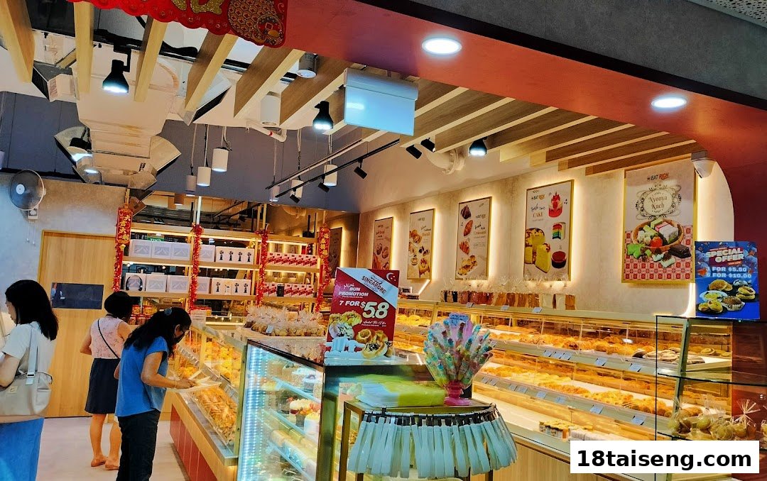 Interior view of Eat Rich bakery, showcasing display cases filled with various fresh baked goods and customers.