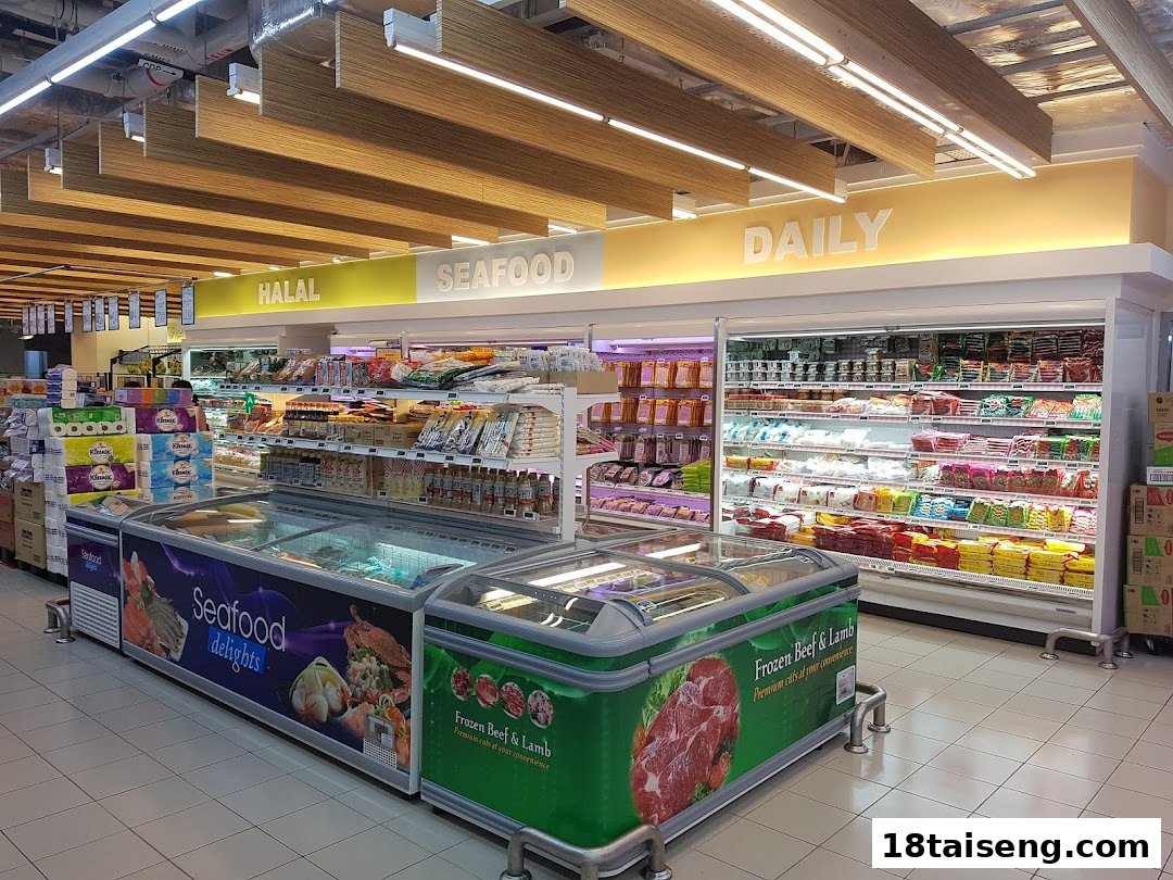 An interior view of a supermarket aisle featuring refrigerated sections for halal, seafood, and daily products.