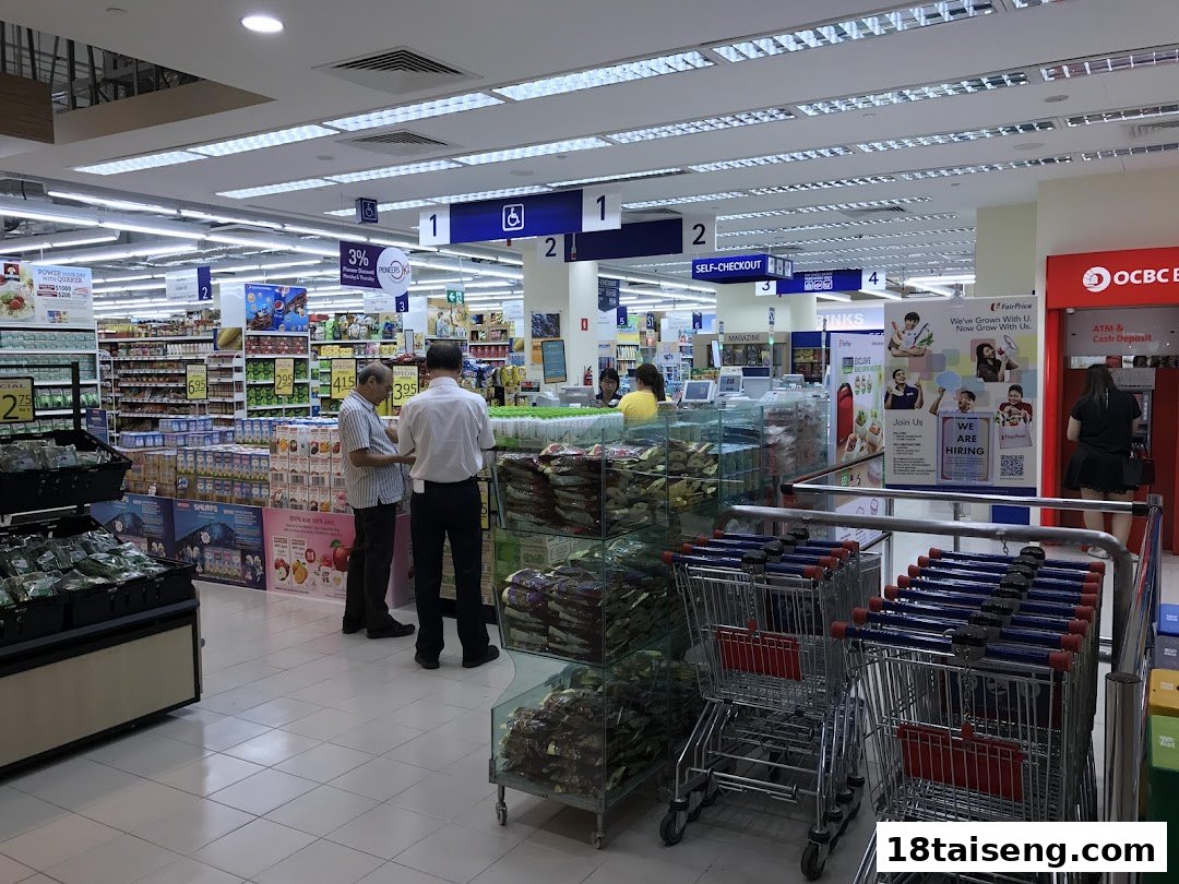 Interior view of FairPrice Tai Seng supermarket, showing aisles, customers, self-checkout, and shopping carts.