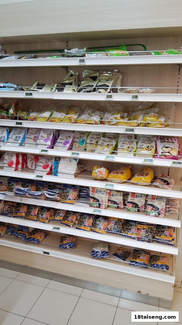 An aisle in FairPrice Tai Seng supermarket displaying shelves stocked with various packaged food items.