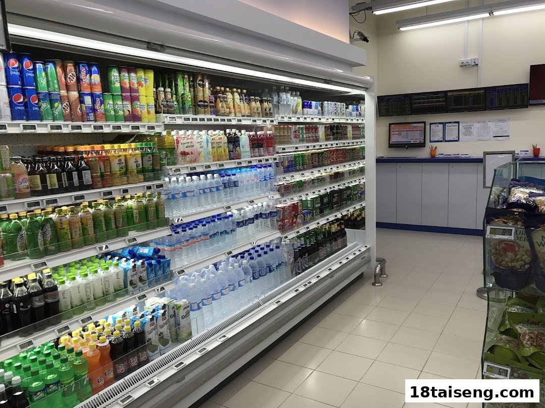 A well-stocked refrigerated aisle displaying a wide variety of beverages at FairPrice Tai Seng.