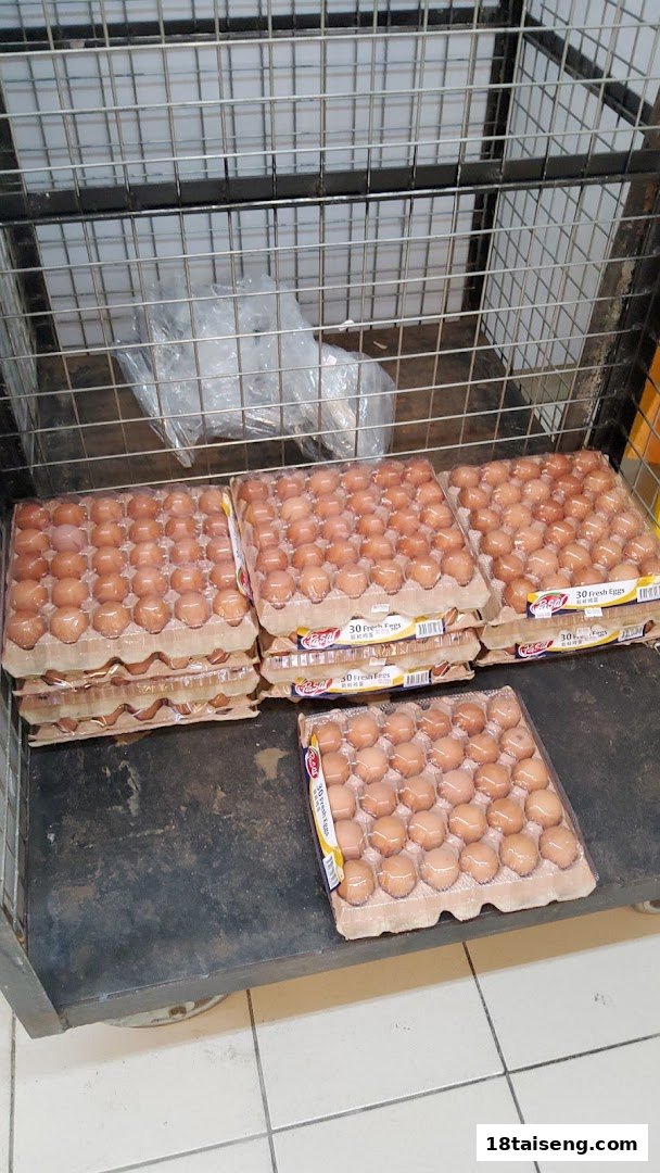 Multiple cartons of fresh eggs are displayed on a metal trolley inside a grocery store.