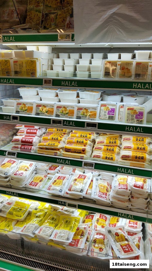 A refrigerated display in FairPrice Tai Seng featuring various Halal-certified tofu and soy products.