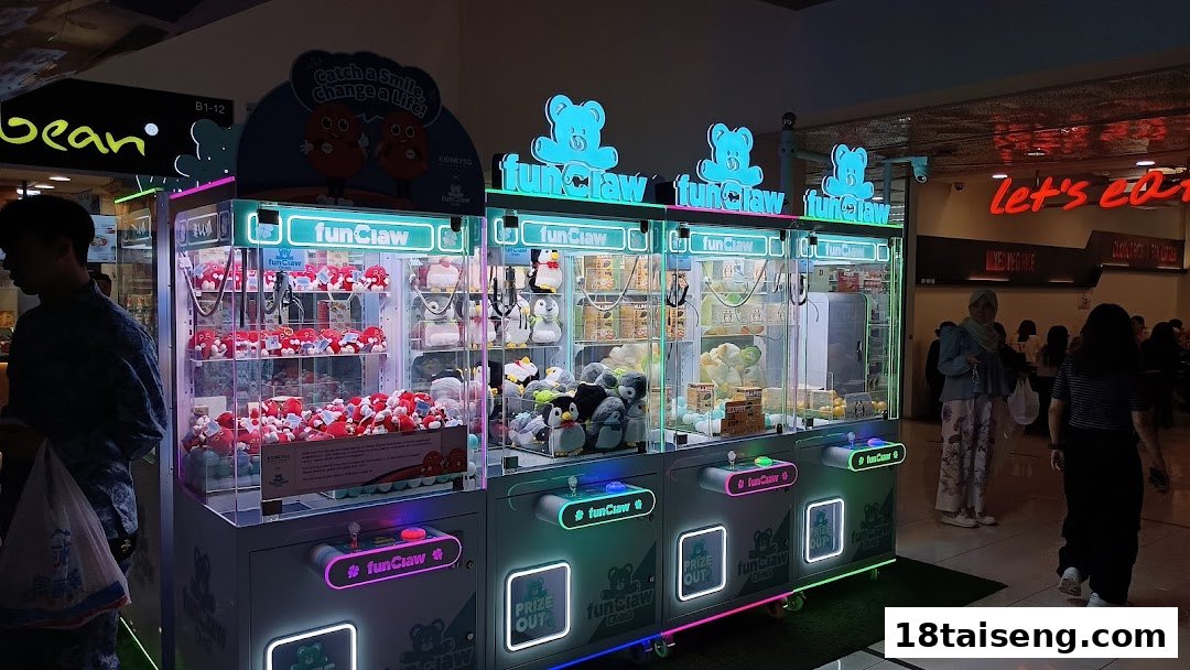 Multiple brightly lit Fun Claw machines filled with plush toys and prizes in a bustling mall setting.