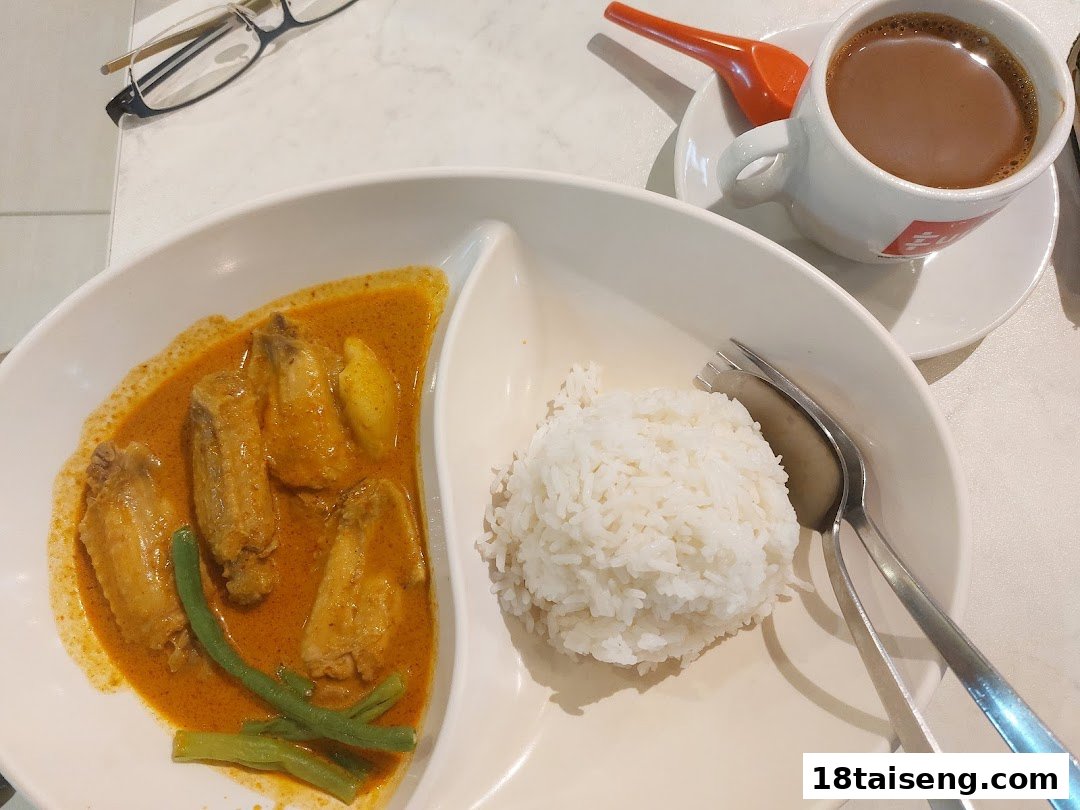 A delicious plate of curry chicken with rice and a cup of coffee or tea from Fun Toast.