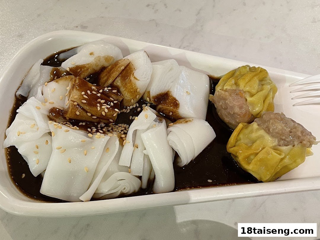 A plate featuring traditional Chee Cheong Fun rice rolls with sauce and two Siew Mai dumplings.
