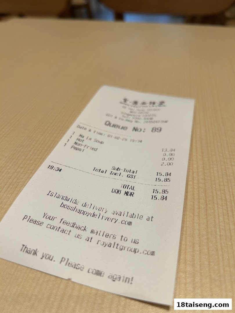 A close-up view of a receipt from Gong Yuan Ma La Tang on a light-colored table.