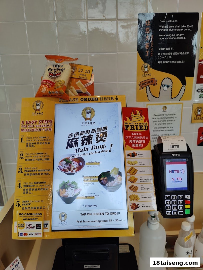 A self-ordering kiosk and payment station at Gong Yuan Mala Tang, displaying ordering steps and food options.