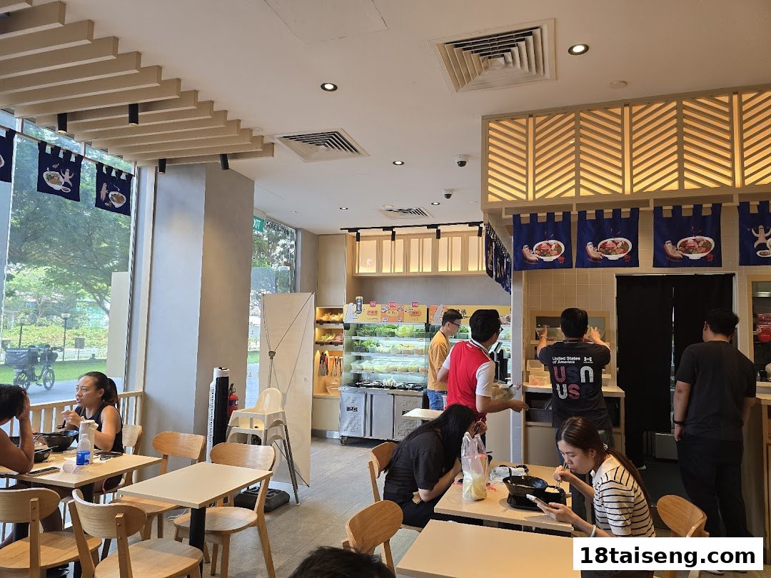 A vibrant interior view of Gong Yuan Ma La Tang, showing customers dining and staff preparing food.