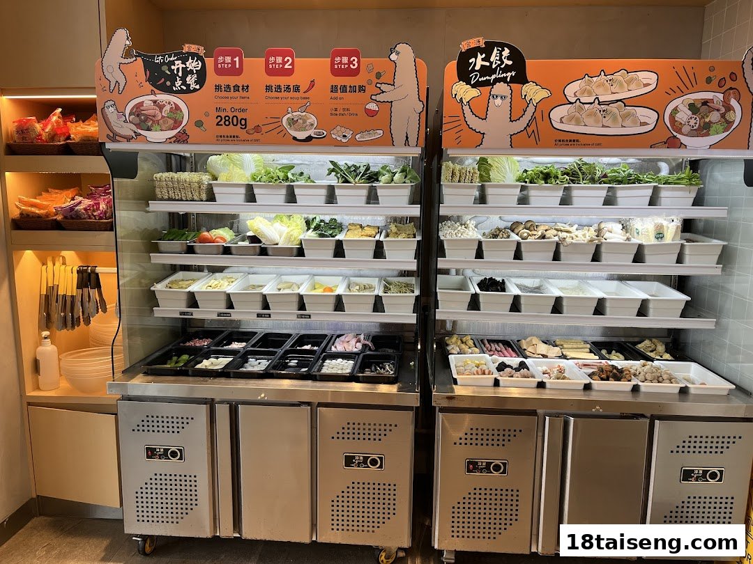A self-service counter displaying a wide variety of fresh ingredients for a customizable hot pot or mala tang meal.