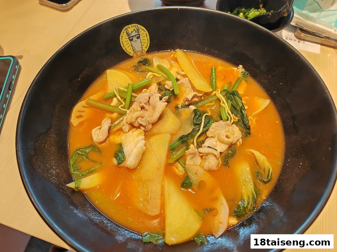 A close-up of a vibrant bowl of mala tang with various ingredients in a black bowl.