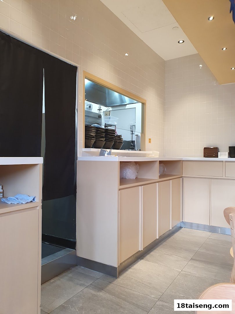 An interior view of Gong Yuan Ma La Tang, featuring a clean counter and a glimpse into the kitchen.