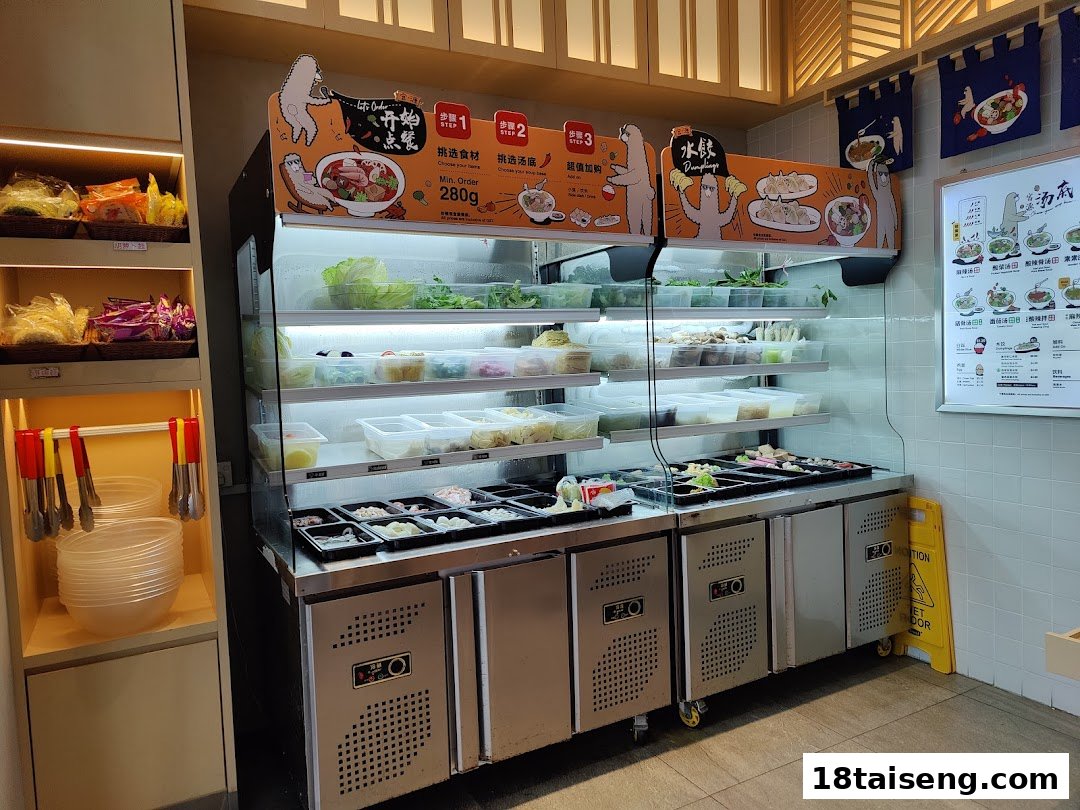 A self-service counter displaying fresh ingredients and a menu board for customizable hot pot.
