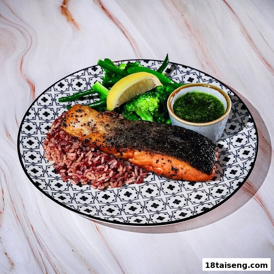 A perfectly cooked salmon fillet served with red rice, green vegetables, and a vibrant green sauce.