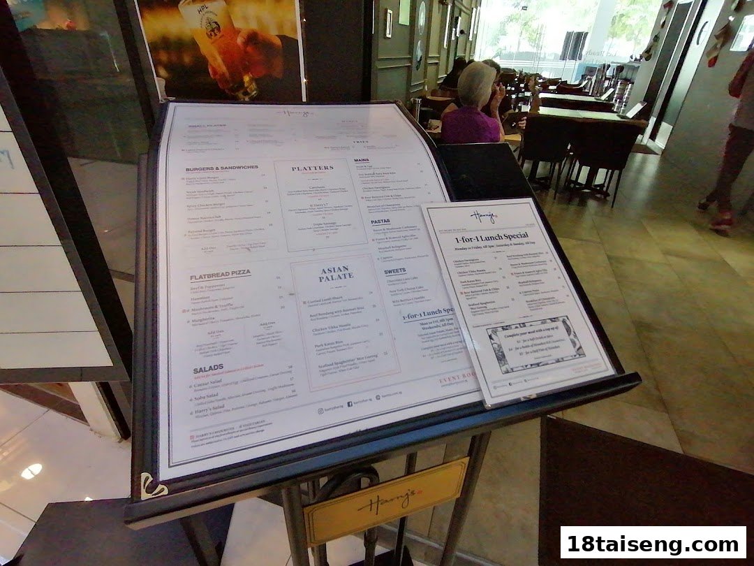 A detailed menu stand for Harry's, showcasing food categories, prices, and a 1-for-1 lunch special.