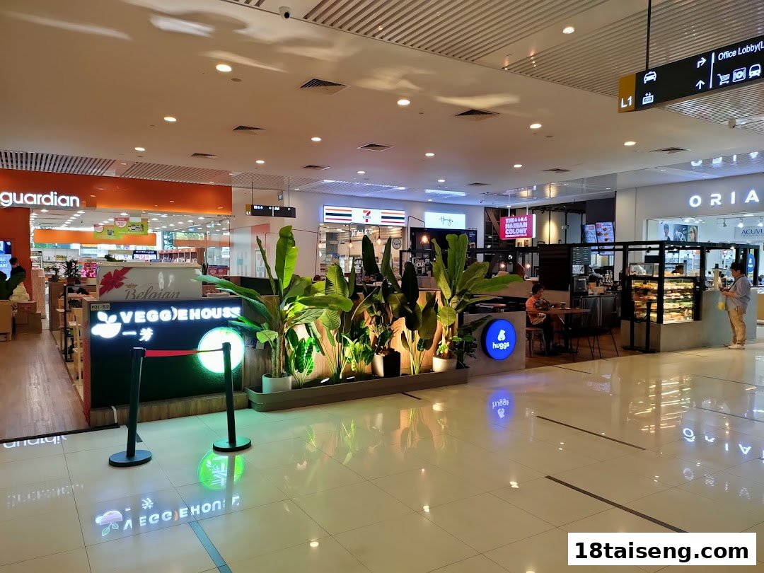Interior view of Huggs Coffee cafe area with seating and plants in a shopping mall.