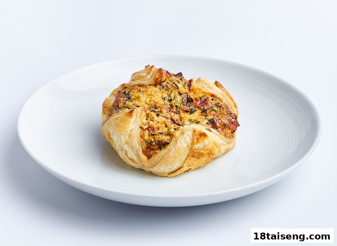 A golden-brown savory pastry, possibly a quiche or tart, rests on a white plate.