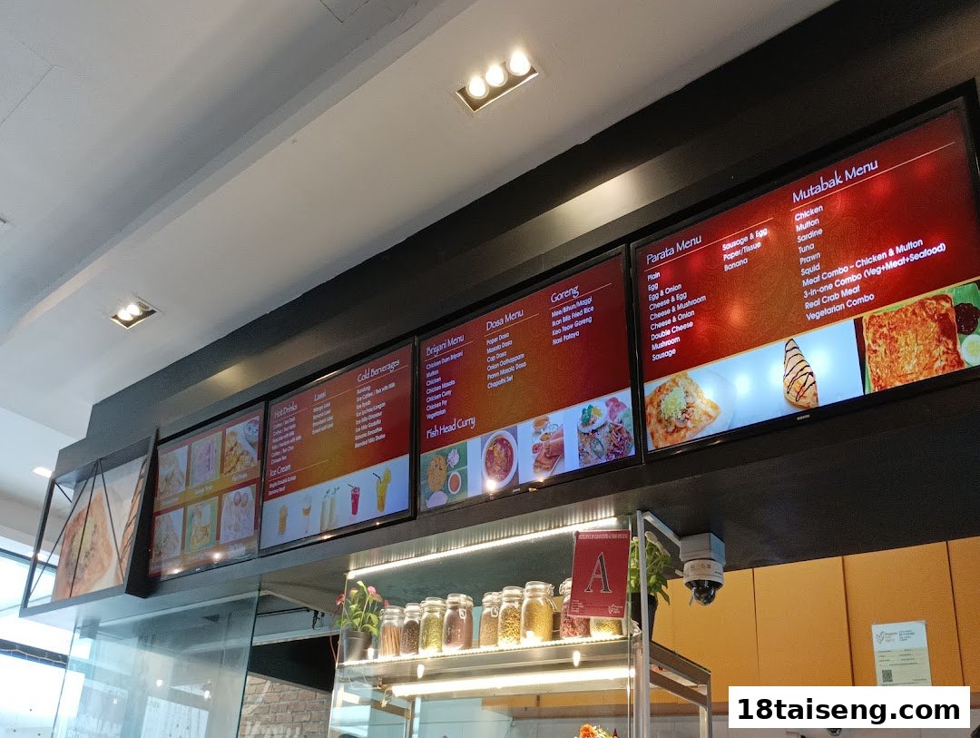 Digital menu boards displaying a variety of Indian and Malay dishes, including prata, biryani, and goreng.