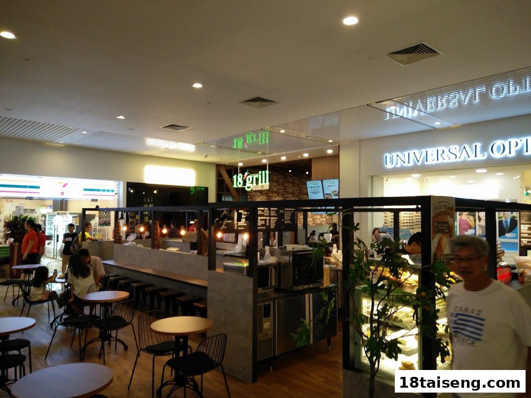 A bustling mall interior featuring the '18 grill' food stall with dining area and adjacent shops.