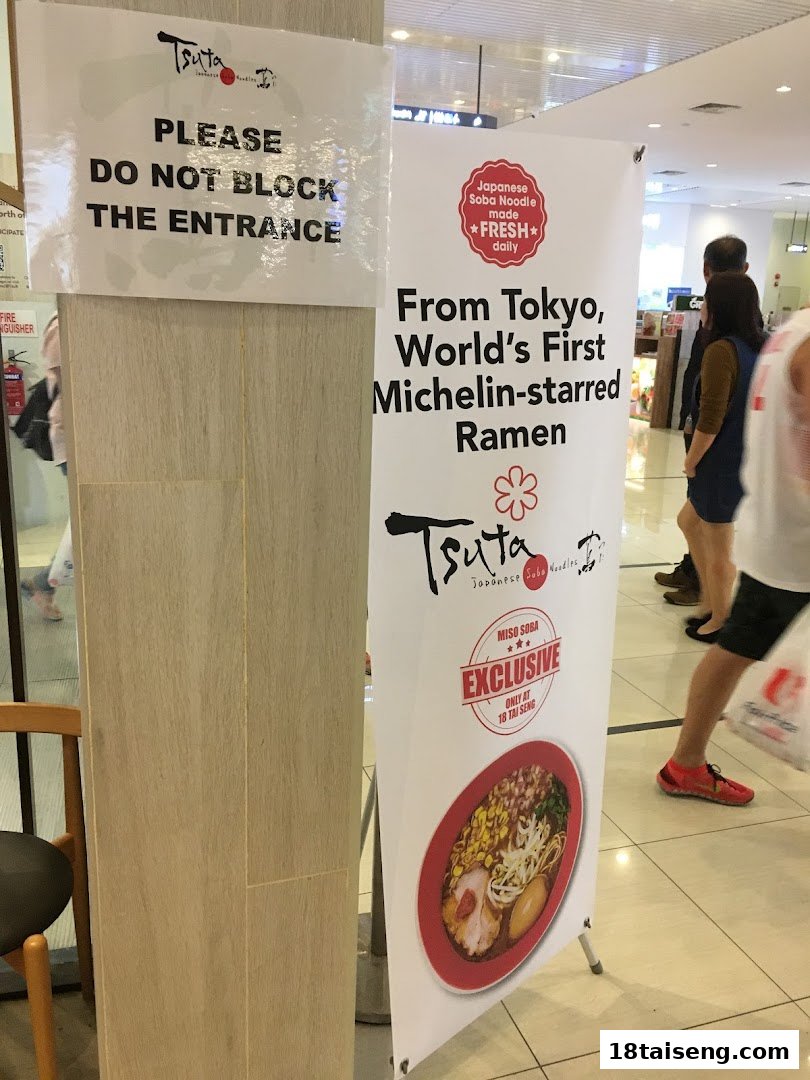 A promotional banner for Tsuta, the world's first Michelin-starred ramen, displayed near an entrance.