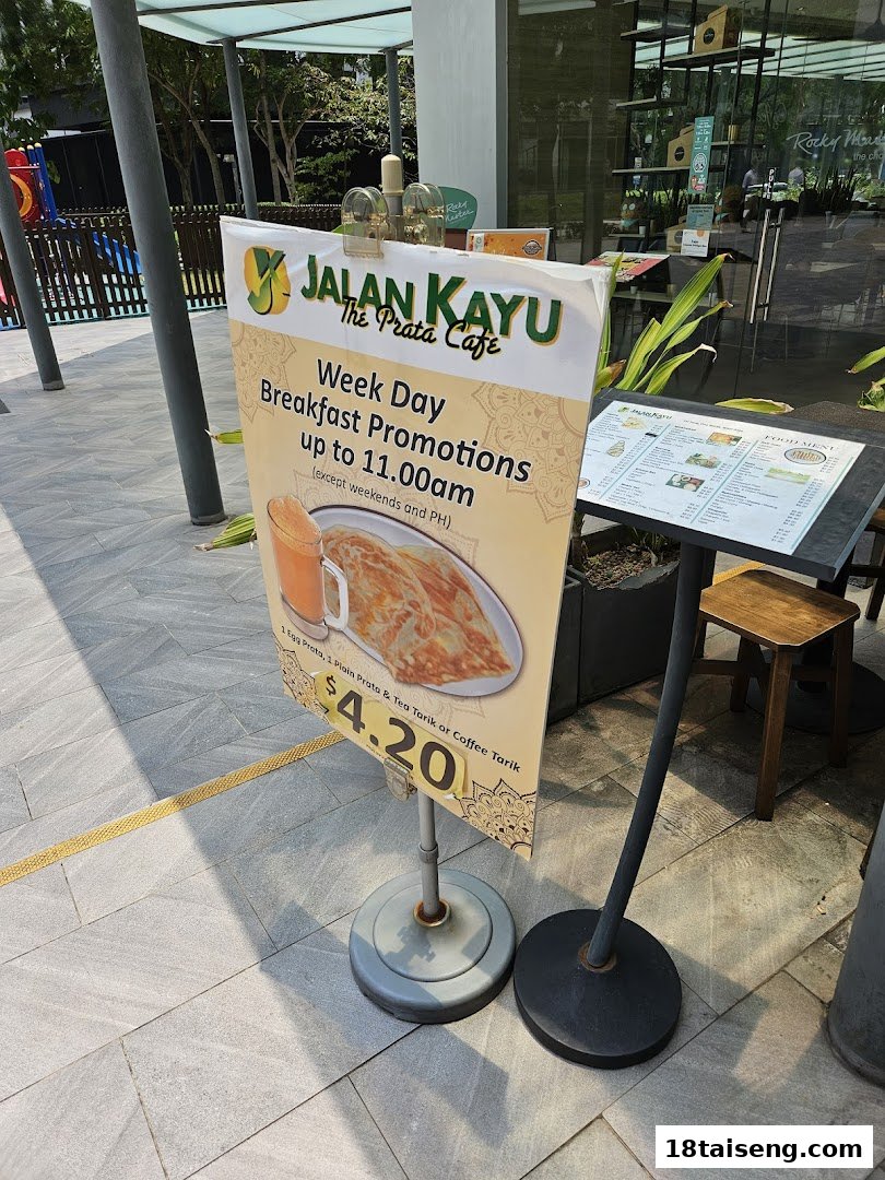 A promotional stand for Jalan Kayu The Prata Cafe's weekday breakfast deal featuring prata and drinks.