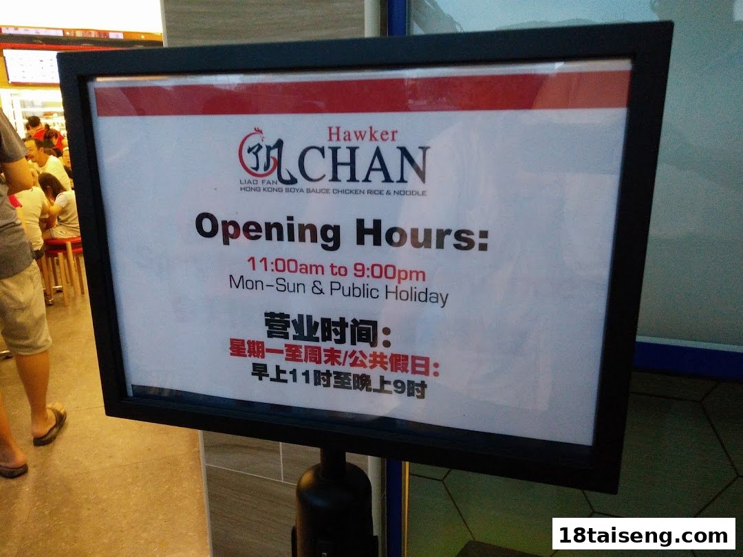 Sign displaying Hawker Chan's opening hours for Hong Kong Soya Sauce Chicken Rice & Noodle.