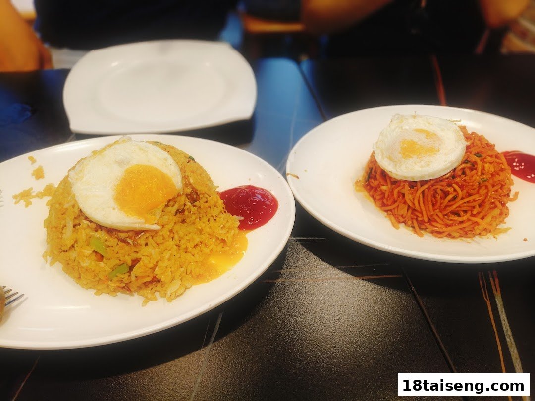 Two plates of delicious Asian-style fried rice and noodles, each topped with a sunny-side-up egg.