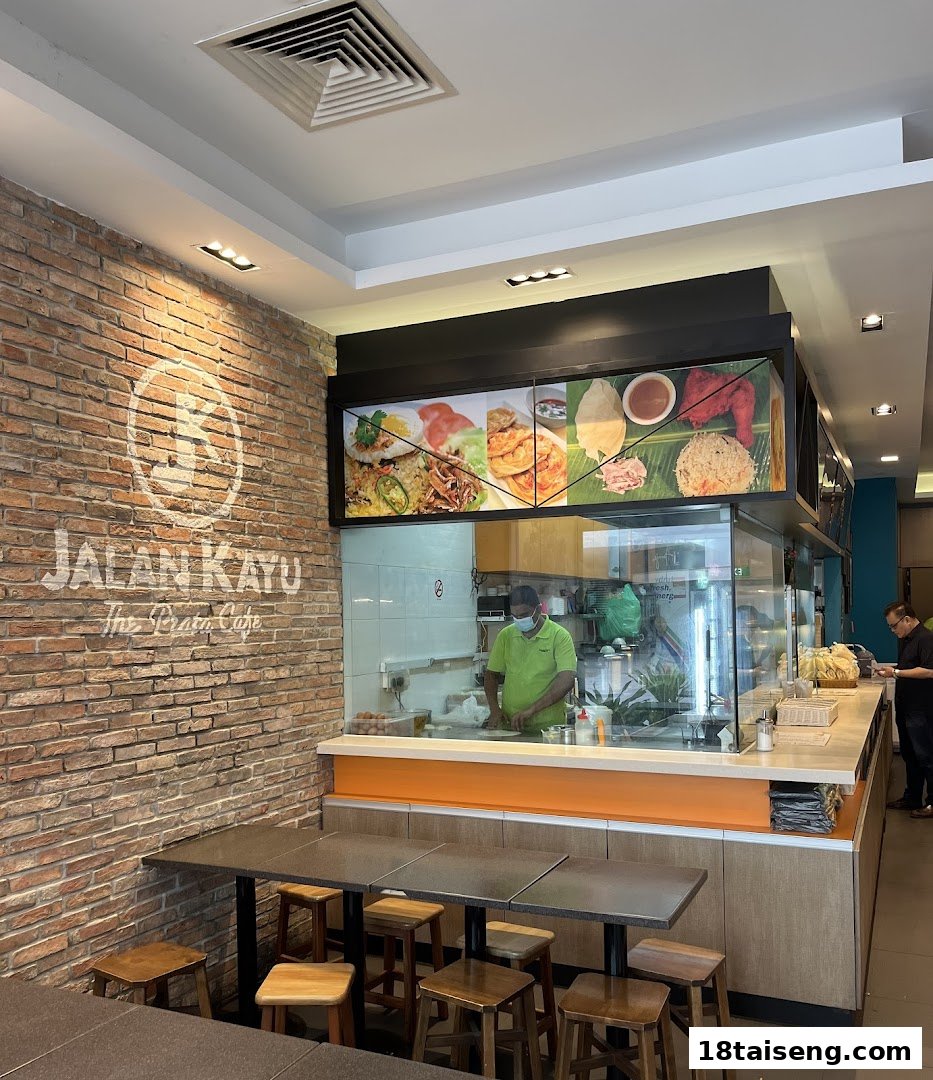 Interior view of Jalan Kayu The Prata Cafe, showing a chef preparing food and dining area.