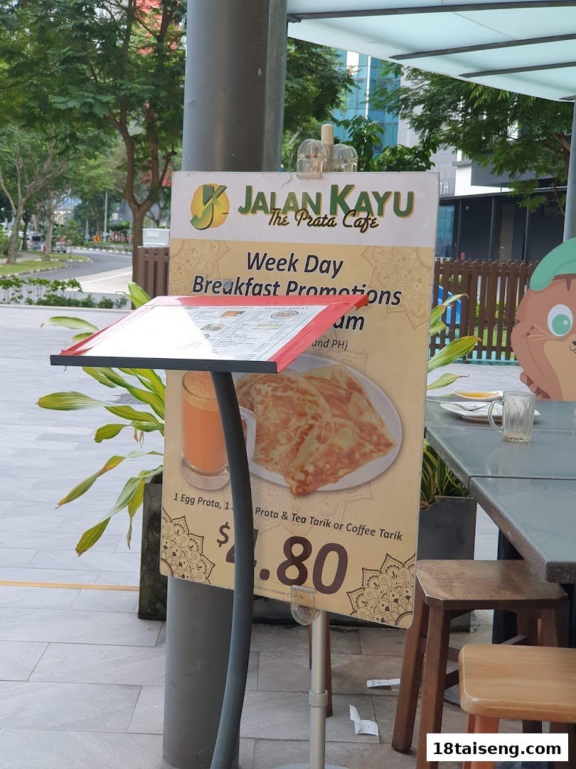 A promotional sign for Jalan Kayu The Prata Cafe's weekday breakfast deal, with outdoor seating.