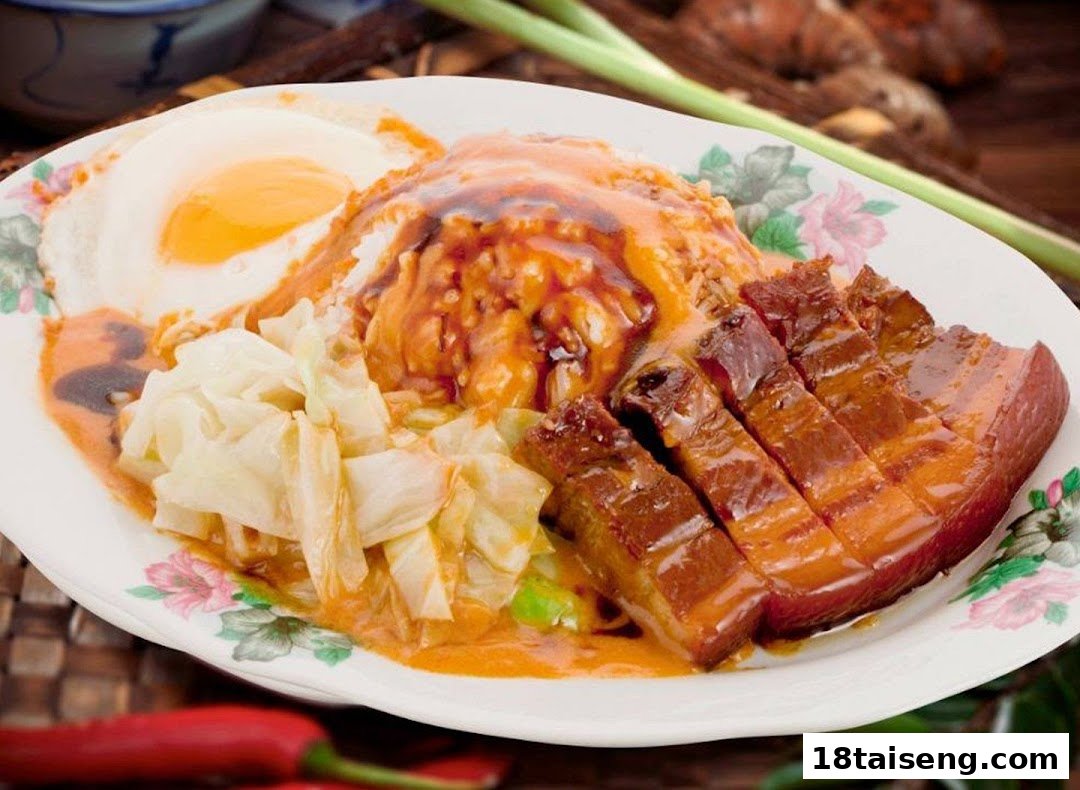 A delicious plate of rice with braised pork belly, fried egg, and cabbage, covered in savory sauce.