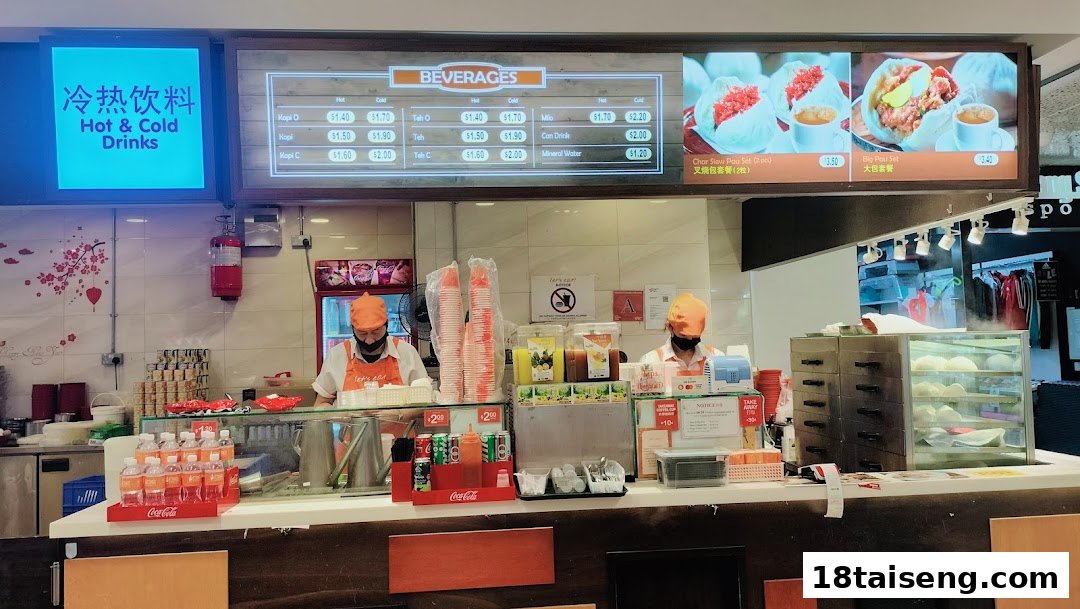 A bustling food stall counter with staff, displaying beverage and food menus.