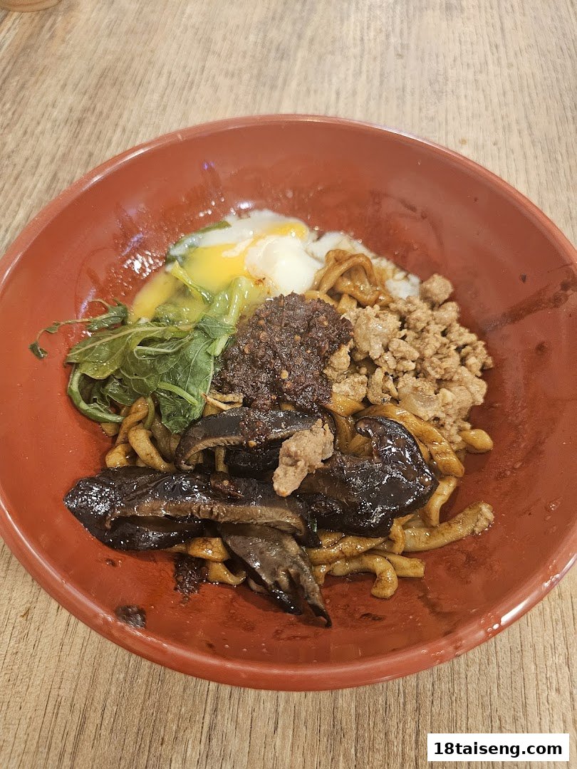 A vibrant bowl of noodles topped with minced meat, mushrooms, greens, chili, and a soft-boiled egg.