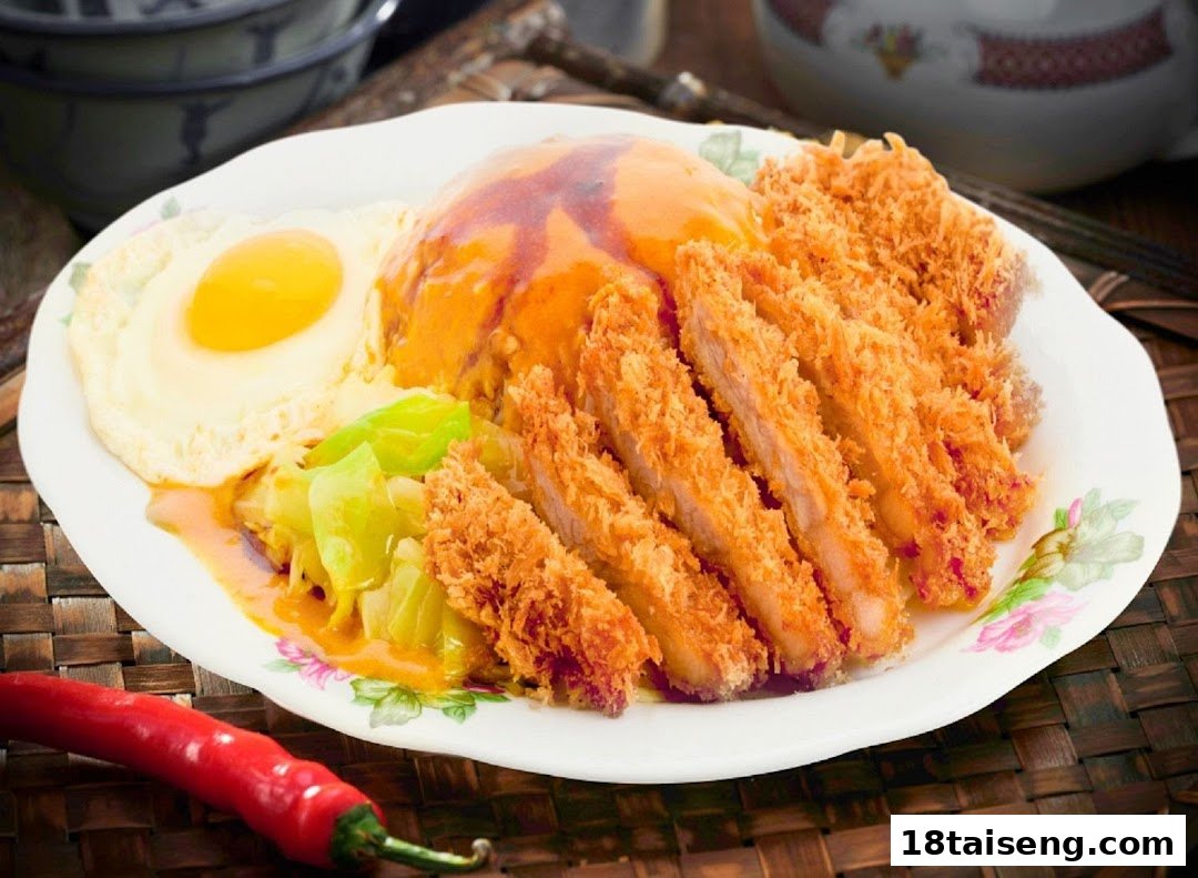 A plate of crispy fried pork cutlets with rice, a fried egg, and cabbage.