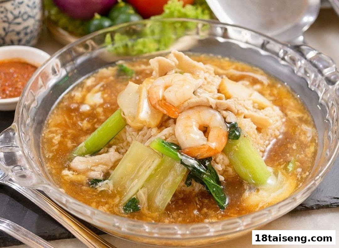 A close-up of a delicious Asian-style dish with prawns, meat, and vegetables in a rich gravy.