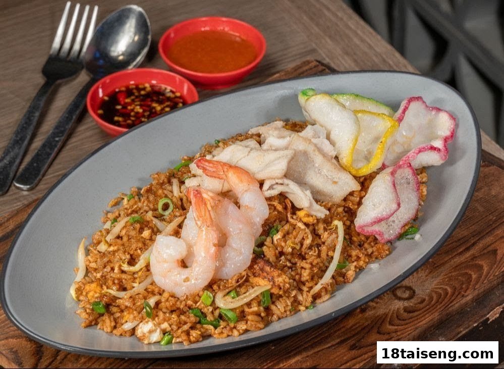A vibrant plate of fried rice topped with shrimp, fish, and colorful crackers, served with dipping sauces.