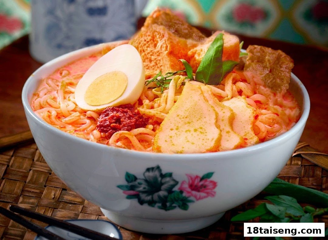 A vibrant bowl of spicy noodles with egg, fish cake, and tofu puffs.