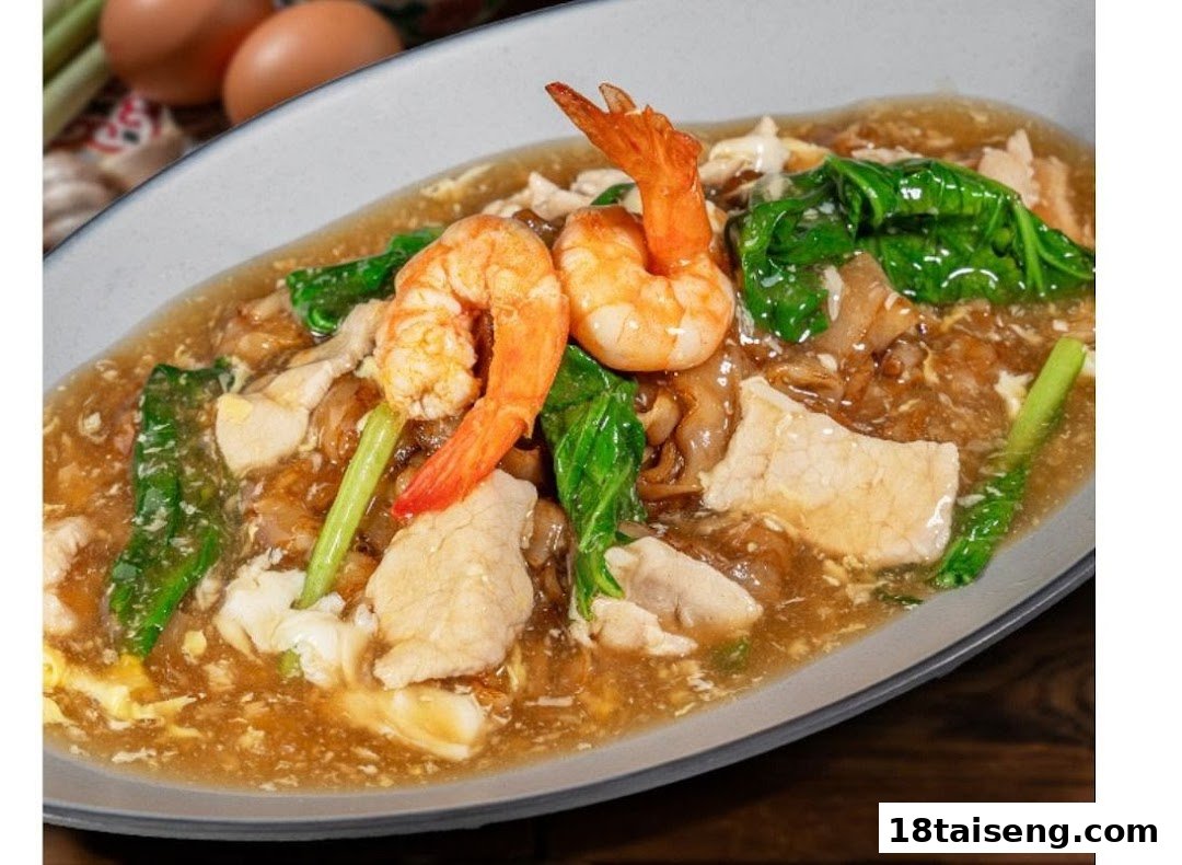A close-up of a delicious noodle dish with shrimp, chicken, and green vegetables in a savory sauce.