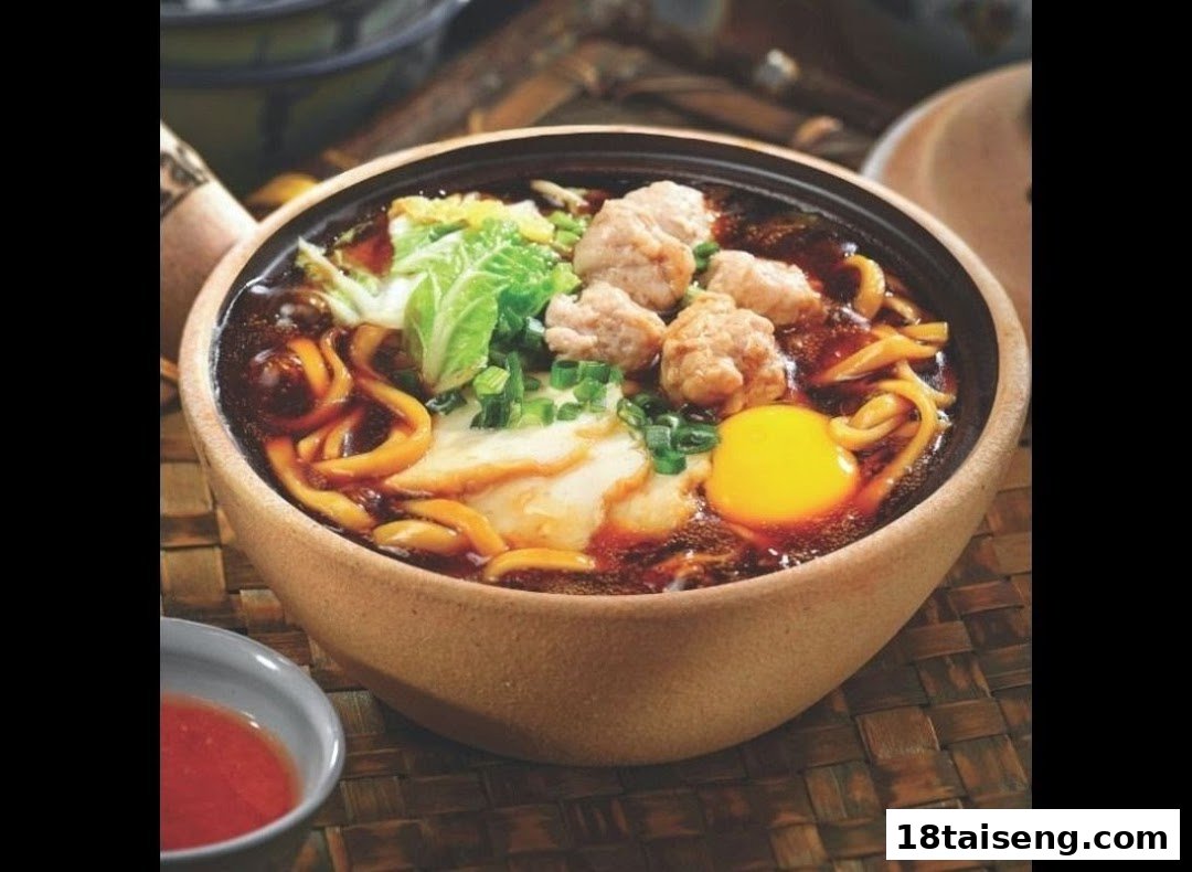 A hearty bowl of noodles with meat, egg, and greens in a rich broth, served in a clay pot.