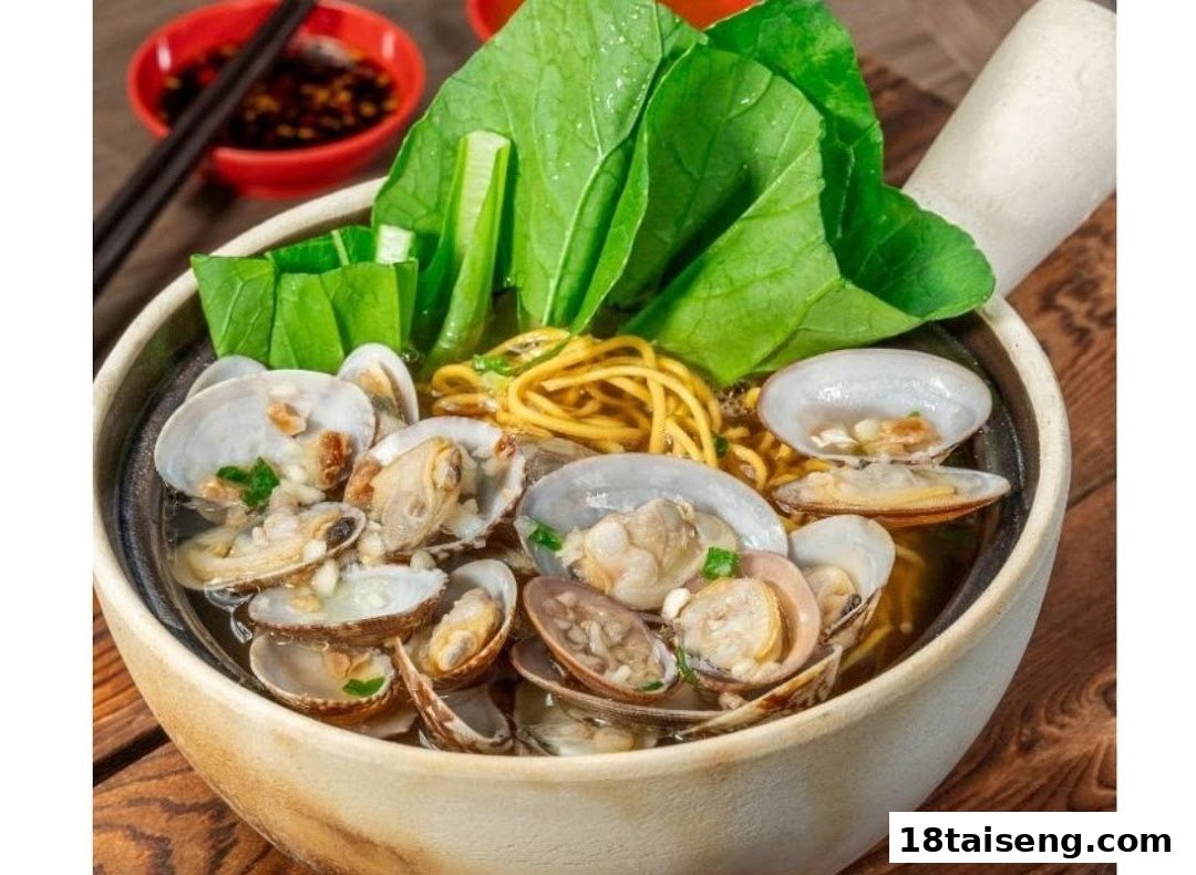 A close-up of a delicious bowl of clam noodles with fresh green vegetables and broth.