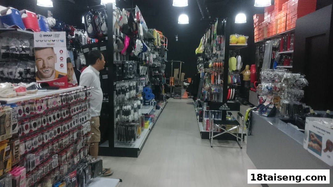 Interior view of Liang Seng Sports, showcasing aisles filled with diverse sports equipment and a customer browsing.