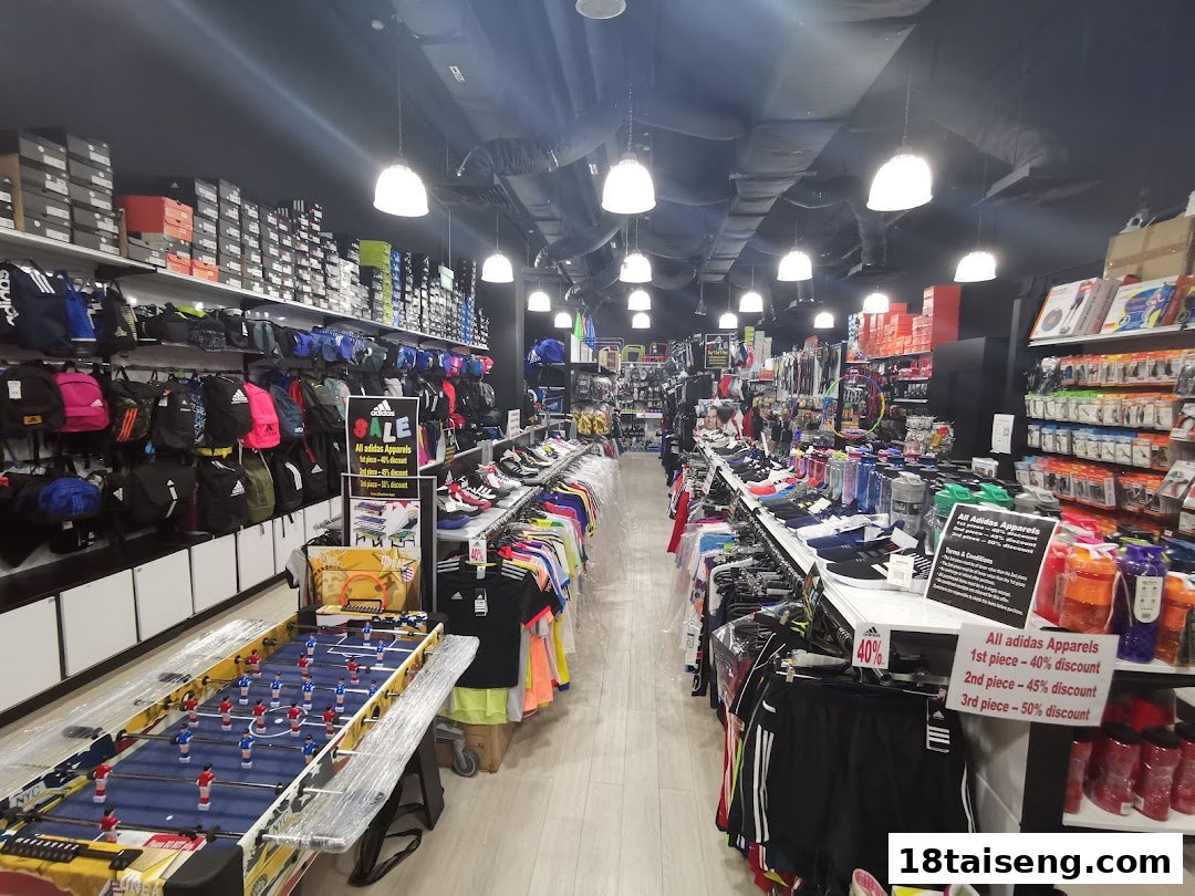 An interior view of a sports shop displaying apparel, bags, footwear, and equipment.